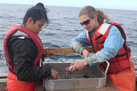 Sarah Henkel with colleague checking out samples in a boat
