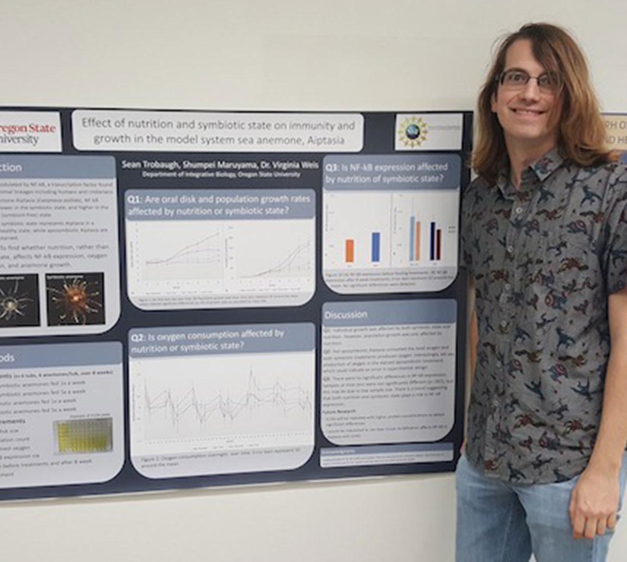 Sean Trobaugh in front of research poster