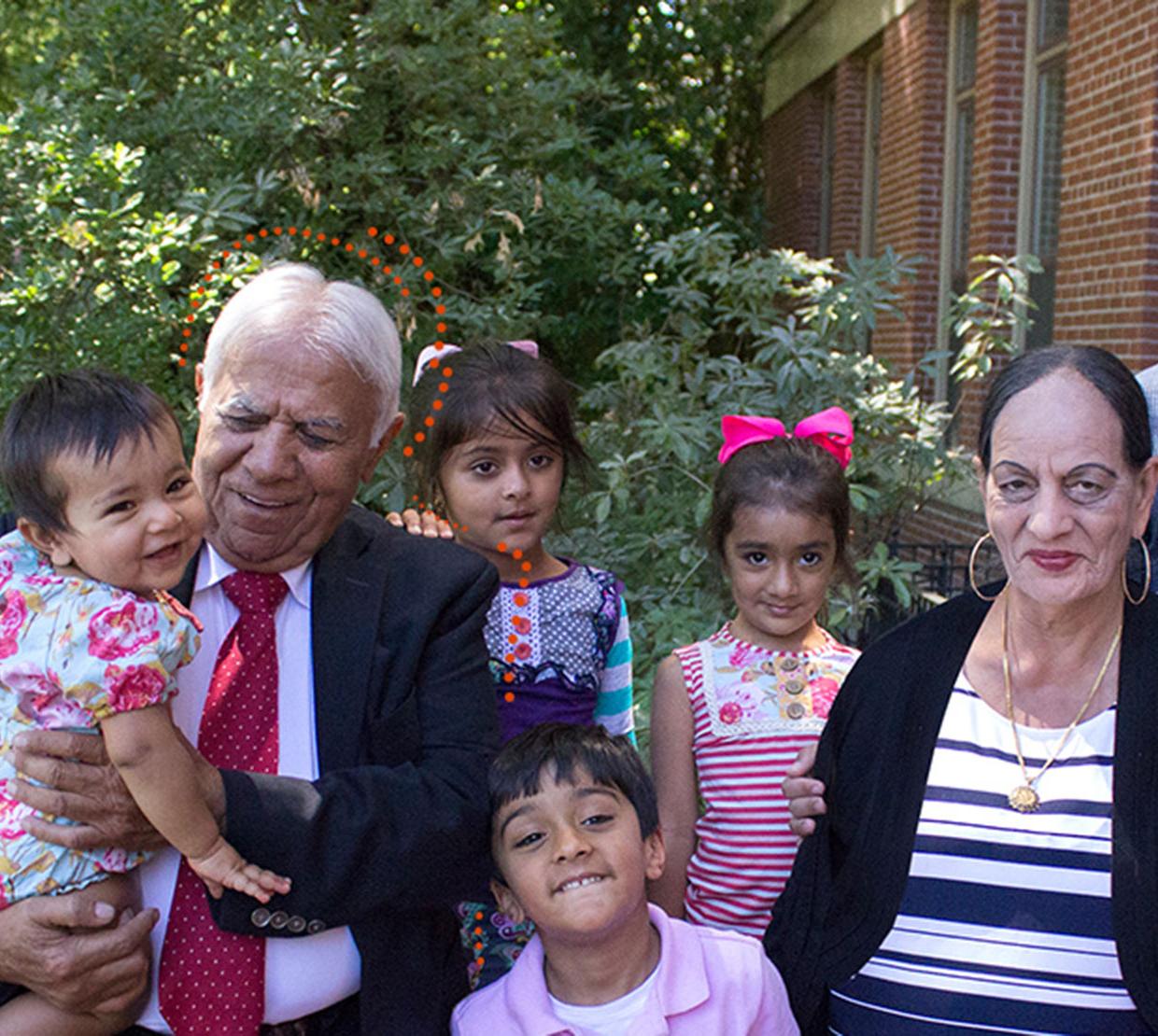 Satnam Sethi with grandchildren and wife standing in front of Kidder Hall