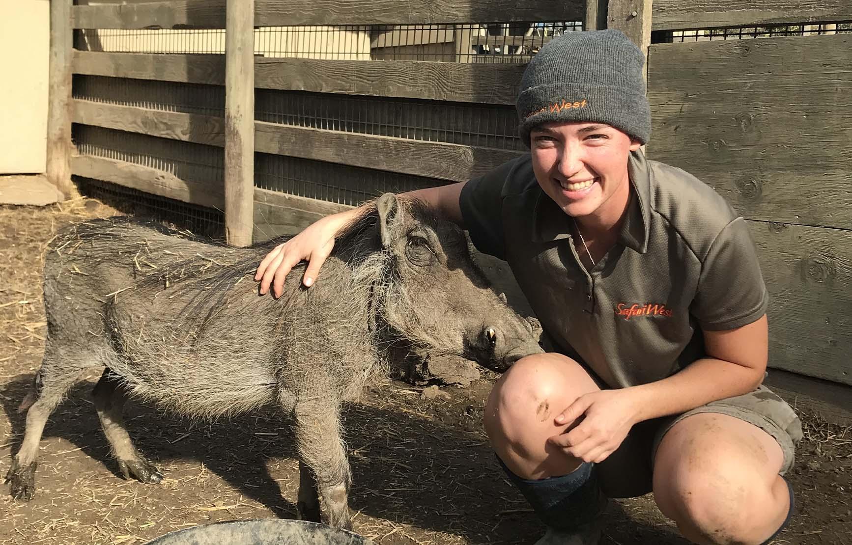 Zoology alumna Molly Cordell with a warthog