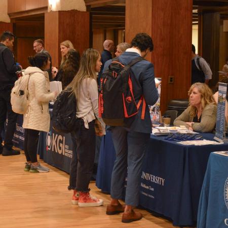 Wide shot of the Health Professions Fair, showing many universities meeting with students