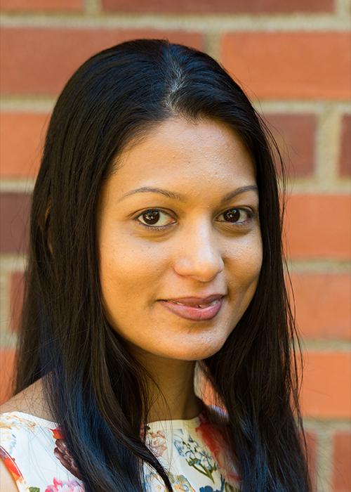Sulochana Wasala standing in front of a brick wall.