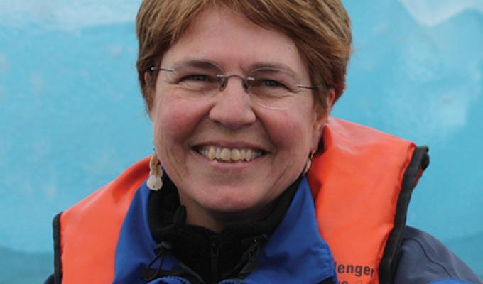 Jane Lubchenco in front of ice glacier wearing life jacket