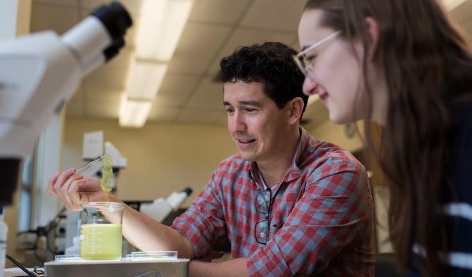 Felipe Barreto looking at lab samples with student