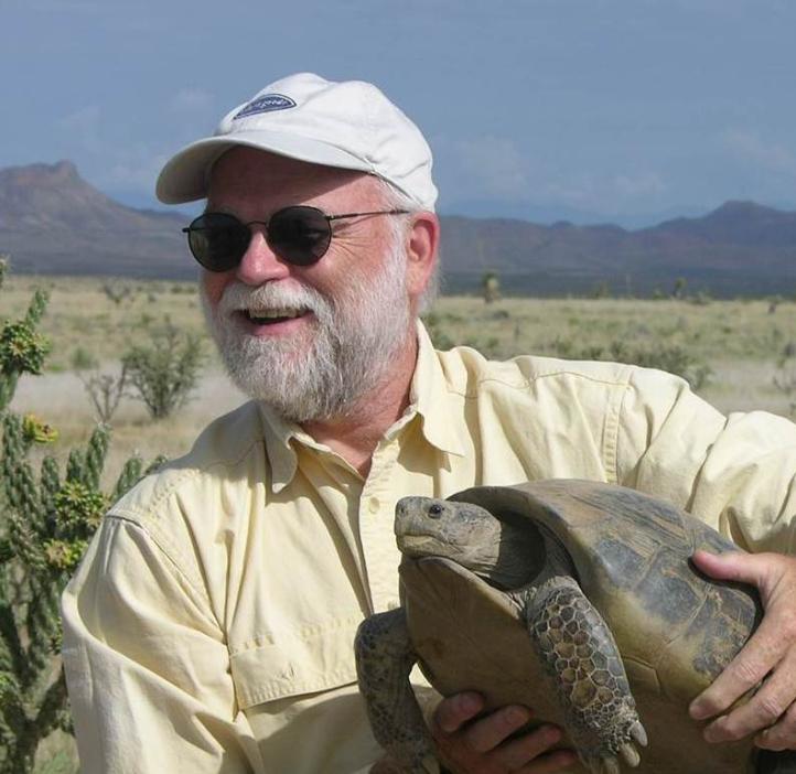 Harry Greene holds a tortoise in a desert setting
