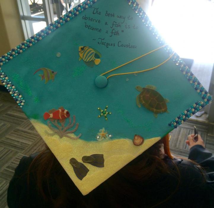 Mortarboard decorated with the beach and Jacques Cousteau quote "The best way to observe a fish is to become a fish"